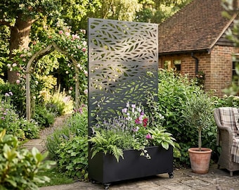 May include: A tall, rectangular, matte black metal planter box featuring an integrated vertical privacy screen with a laser-cut leaf pattern. The planter is equipped with small wheels at the base and is filled with various green plants and flowers.