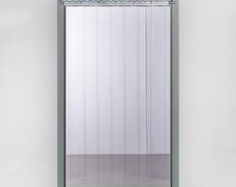 May include: A clear plastic strip door installed in a gray metal frame. The door is composed of vertical, transparent strips hanging from a metal track. The door is set against a white wall and a gray floor.