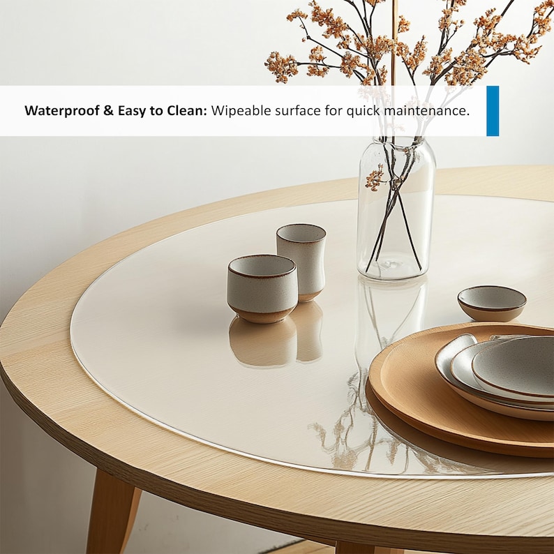 Puede incluir: Un protector de mesa redondo transparente con un borde ligeramente elevado, colocado sobre una mesa de madera clara. El protector est&aacute; dise&ntilde;ado para proteger la superficie de la mesa de ara&ntilde;azos y derrames. El texto "Waterproof & Easy to Clean: Wipeable surface for quick maintenance." es visible en la imagen.
