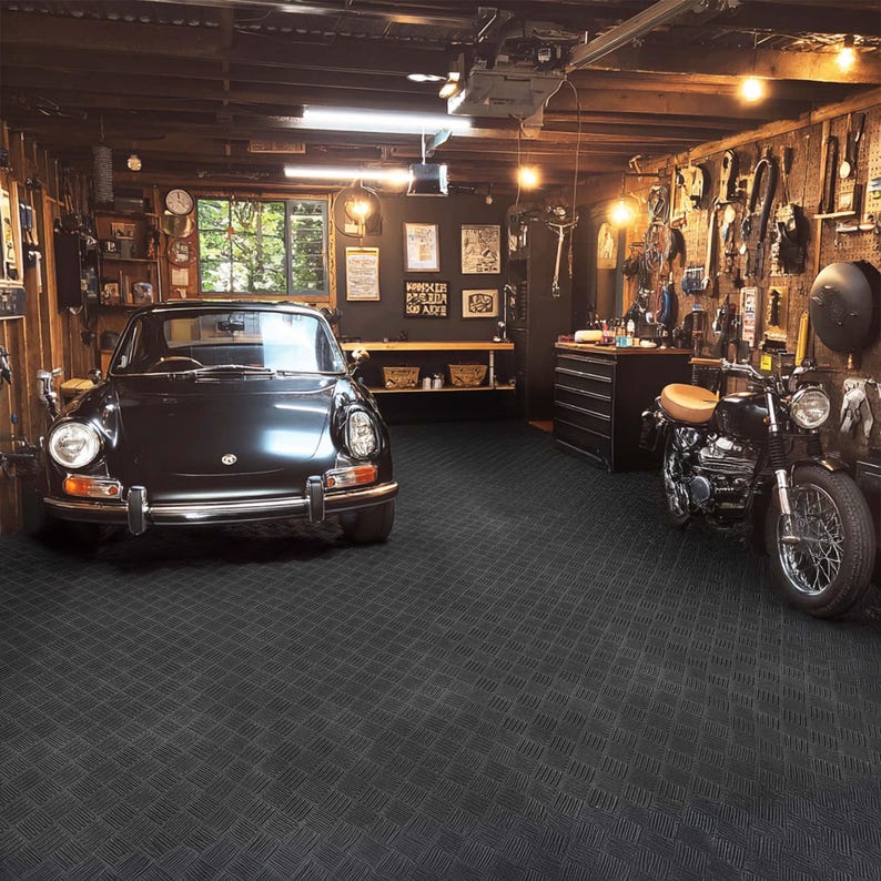 May include: A classic black car and a black motorcycle are positioned inside a garage with wooden walls. The garage is illuminated with various tools and equipment displayed on the walls, creating a classic automotive and motorcycle theme.