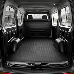 May include: Interior view of a black cargo van, featuring a diamond-patterned floor mat. The van has two rear seats and side windows. The space is empty and well-maintained, ready for cargo.