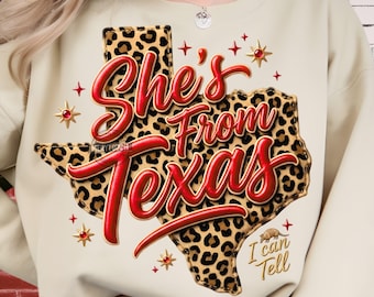May include: A cream-coloured sweatshirt featuring a leopard print Texas outline and the red text "She's From Texas". The design includes red stars and the phrase "I can tell".