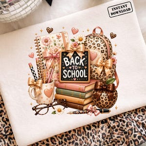 Pode incluir: Uma ilustração digital com um caderno de espiral, uma mochila com estampa de leopardo, três livros empilhados, uma caneca com lápis, óculos e uma maçã, decorados com laços e flores. Uma placa diz BACK TO SCHOOL. O texto diz INSTANT DOWNLOAD.