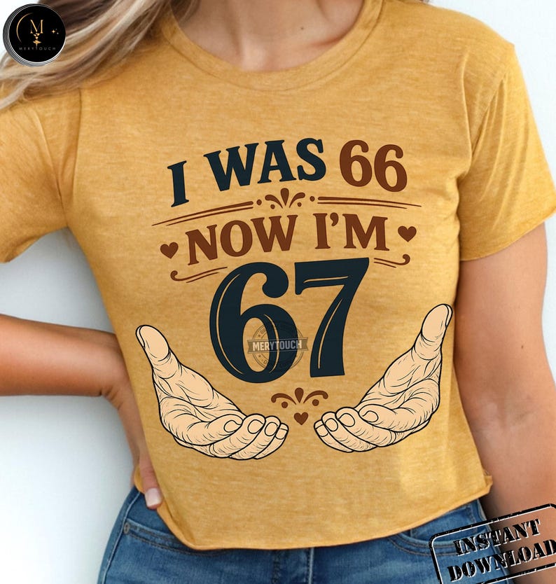 Puede incluir: Camiseta de color amarillo mostaza con el texto "I WAS 66 NOW I'M 67" en azul marino y marr&oacute;n. El n&uacute;mero 67 es grande y azul marino, con dos manos abiertas a cada lado. La camiseta es de estilo crop.