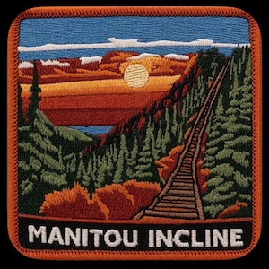 May include: A square embroidered patch with an orange border featuring a landscape of the Manitou Incline. The scene depicts a steep wooden staircase ascending through a forest of green pine trees toward a sunset with orange and yellow hues.