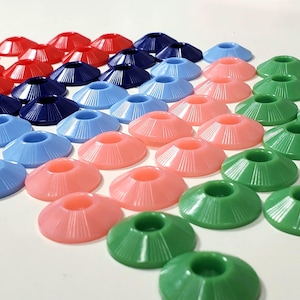 May include: A collection of colorful, plastic, cone-shaped objects in red, navy blue, light blue, pink, and green. The objects have a circular opening at the top and are arranged in rows. The objects have a ridged design.