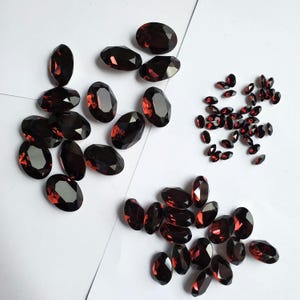 Cristais Swarovski 4120 ovais na cor bordô, com base em ponta folheada, para confecção de joias.