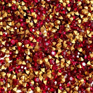 Könnte beinhalten: Nahaufnahme einer großen Menge roter und goldener Strasssteine. Die Strasssteine sind zufällig verteilt und scheinen aus Glas zu sein.