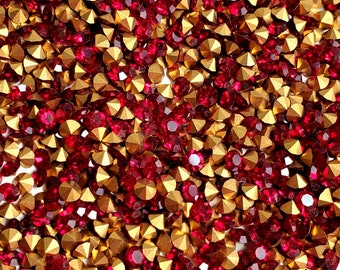 Puede incluir: Una imagen de primer plano de una gran cantidad de piedras de cristal rojas y doradas. Las piedras de cristal están dispersas al azar y parecen estar hechas de vidrio.