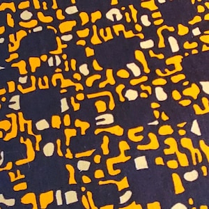 Könnte beinhalten: Nahaufnahme eines Stoffes mit sich wiederholendem Muster. Das Design zeigt einen dunkelblauen Hintergrund mit einem sich wiederholenden Muster aus gelben und weißen Formen. Die Formen sind abstrakt und geometrisch und erzeugen ein strukturiertes Aussehen.