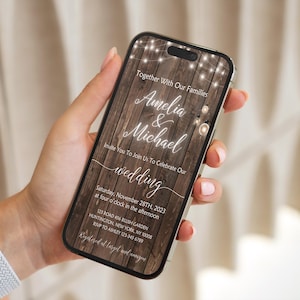 Może przedstawiać: Ruskie zaproszenie ślubne na ekranie smartfona z drewnianym tłem i światełkami. Zaproszenie brzmi: "Razem z naszymi rodzinami, Amelia & Michael, zapraszamy Was do świętowania naszego ślubu, w sobotę, 28 listopada 2023, o godzinie 16:00, 123 Ford 406 Rushi Garden, Huntington, Nowy Jork 1233456789".