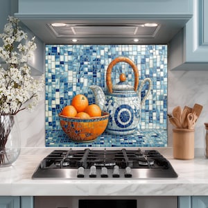 May include: A kitchen scene featuring a blue and white ceramic teapot with a wooden handle, a mosaic bowl of oranges, and a vase of white flowers. The background has a blue tile backsplash. The kitchen cabinets are painted light blue.