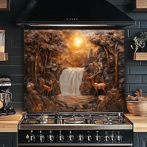 May include: A kitchen splashback with a detailed relief of a waterfall scene, featuring deer, trees, and a full moon. The colour palette includes shades of brown, beige, and gold, creating a warm, natural aesthetic. The splashback is mounted above a black cooker.