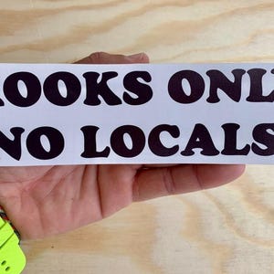 May include: White sticker with black text that reads "Kooks Only No Locals".