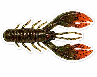 Puede incluir: Imagen detallada de un señuelo de pesca de plástico con forma de cangrejo de río. El señuelo es principalmente verde oscuro con pinzas y detalles en naranja. Tiene un cuerpo segmentado, múltiples patas y antenas detalladas.