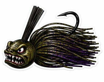 Puede incluir: Una pegatina de un señuelo de pesca detallado con una cara enfadada y caricaturesca. El señuelo tiene un cuerpo verde y morado, un anzuelo negro y una cola negra en forma de pelo. La cara es verde oliva con detalles rojos y dientes blancos afilados.