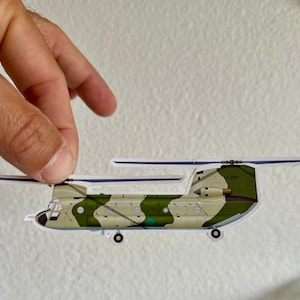 May include: A green, white, and brown camouflage helicopter sticker with the text "LC-GCR" on the side.