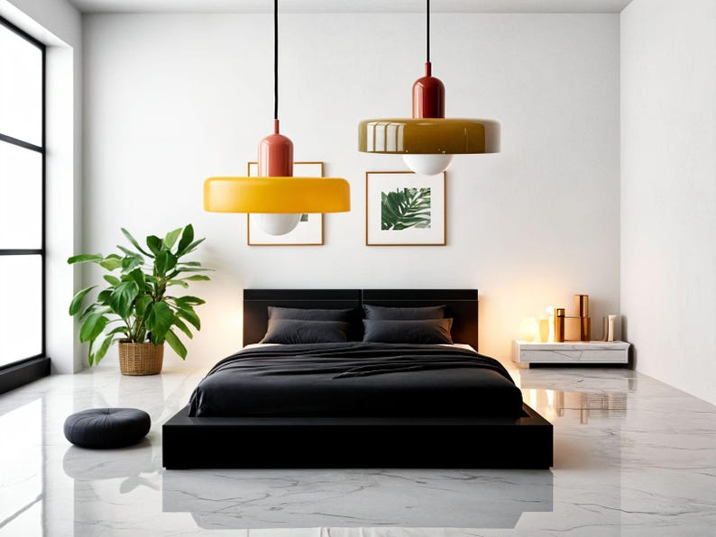 May include: A modern bedroom with a black platform bed, black bedding, and two yellow and brown pendant lights hanging from the ceiling. The room has a white wall, a large window, and a small plant in a brown pot.