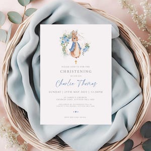 May include: Christening invitation with a Peter Rabbit illustration in a floral wreath. The invitation reads "Please join us for the Christening of our son, Charlie Thomas." Details include the date, time, and location.