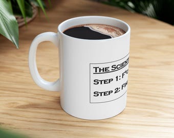 May include: White ceramic coffee mug with a black handle. The mug has black text that reads "THE SCIENTIST'S METHOD" and "STEP 1: F*CK IT UP" and "STEP 2: FIX IT".