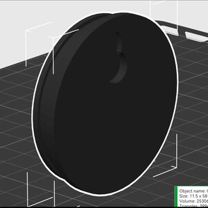 Op de afbeelding: Een zwart, cirkelvormig object met een gebogen inkeping aan de bovenkant. Het object heeft een witte omtrek en lijkt een 3D-geprint ontwerp te zijn. De afmetingen zijn 11,5 x 58.