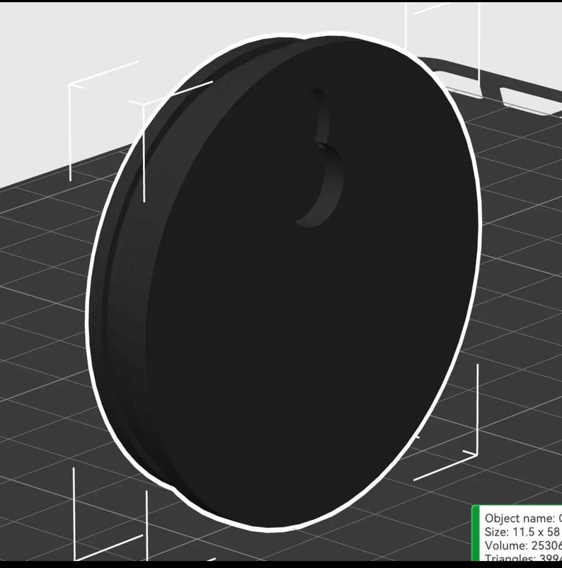 Op de afbeelding: Een zwart, cirkelvormig object met een gebogen inkeping aan de bovenkant. Het object heeft een witte omtrek en lijkt een 3D-geprint ontwerp te zijn. De afmetingen zijn 11,5 x 58.