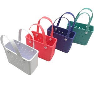 May include: Four brightly coloured tote bags. The bags are white, coral, purple, and teal. Each bag has a matching handle and is made of a solid material with small holes. The bags are rectangular in shape.
