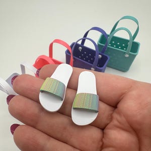 May include: A set of three ceramic mugs with a speckled, matte finish. The mugs are in cream, light grey, and dark grey. Each mug has a simple, minimalist design, ideal for coffee or tea.