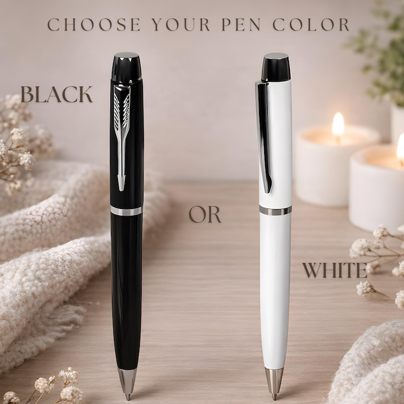 May include: Two ballpoint pens, one black and one white, each featuring a silver-toned clip and tip. The text CHOOSE YOUR PEN COLOR is at the top, with BLACK next to the black pen, OR in the center, and WHITE next to the white pen.