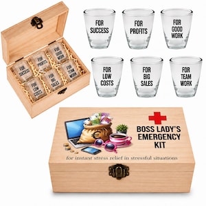 Peut inclure: Une boîte en bois marquée BOSS LADY'S EMERGENCY KIT avec une croix rouge, contenant six verres à shot transparents. Chaque verre porte un texte noir : FOR SUCCESS, FOR PROFITS, FOR GOOD WORK, FOR LOW COSTS, FOR BIG SALES et FOR TEAM WORK.