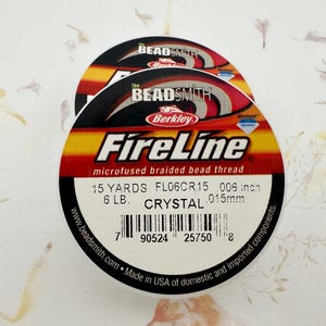 May include: Two spools of FireLine microfused braided bead thread. The labels are black, red, and yellow with the text "FireLine" and "Berkley". Each spool contains 15 yards of thread, 6 pounds, and is 0.006 inch in diameter.