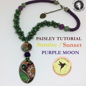 May include: A purple and green beaded necklace with a paisley-patterned pendant. The pendant is made of ceramic and has a green, orange, and white design. The necklace is called "Paisley Tutorial Sunrise / Sunset Purple Moon" and is by Jasmine Tea Designs.