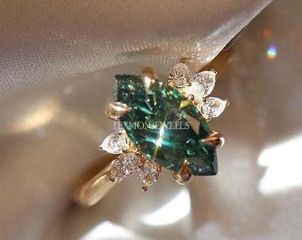 May include: A gold ring with a marquise-shaped green gemstone surrounded by smaller white gemstones.