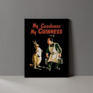 May include: Black framed print featuring a vintage advertisement. The image shows a kangaroo holding a bottle and a man carrying buckets, with the text "My Goodness My Guinness" in red and orange.