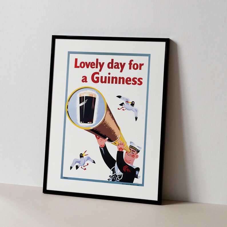 May include: Framed print featuring a vintage advertisement. The artwork depicts a sailor looking through a telescope at a pint of Guinness, with seagulls in the background. The text reads "Lovely day for a Guinness."