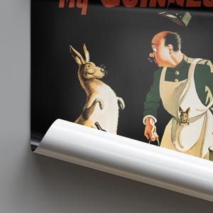 K&ouml;nnte beinhalten: Vintage Werbeplakat mit einem Cartoon-K&auml;nguru und einem Mann in gr&uuml;ner Jacke und Sch&uuml;rze. Das K&auml;nguru l&auml;chelt, und der Mann wirkt &uuml;berrascht. Das Plakat hat einen schwarzen Hintergrund mit den Worten "My Guinness".