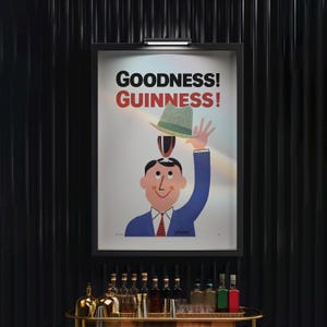 Puede incluir: Un p&oacute;ster vintage enmarcado de Guinness. Presenta un hombre de dibujos animados con traje azul y corbata roja, equilibrando un sombrero sobre su cabeza. El texto "GOODNESS! GUINNESS!" se muestra encima de la ilustraci&oacute;n. El p&oacute;ster est&aacute; montado en una pared negra.