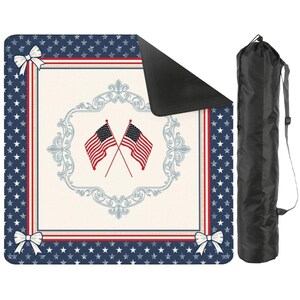 May include: A square outdoor blanket featuring a navy blue border with white stars and white corner bows. The center is cream-colored with a light blue ornate frame surrounding two crossed American flags. The blanket has a black underside and a black bag.