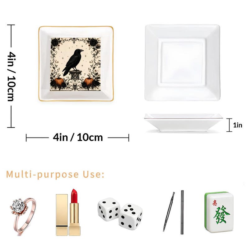 May include: Two square white ceramic trinket trays measuring 4 inches by 4 inches by 1 inch. One tray features a black raven, pumpkins, and floral scrollwork. The other is plain white. Below are a ring, lipstick, two dice, pens, and a mahjong tile.