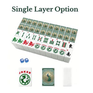 Puede incluir: Un juego de fichas de Mahjong blancas con s&iacute;mbolos de dragones verdes y rojos, texto Joker y patrones de bamb&uacute; numerados. El reverso de las fichas muestra un dise&ntilde;o de pavo real en azul verdoso. Incluye dos dados azules. Texto Single Layer Option.