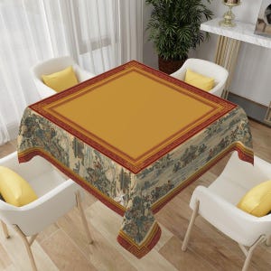 May include: A square tablecloth with a mustard yellow center and a decorative border. The border is red with a geometric pattern. The edges feature a detailed illustration of a historical scene. The tablecloth is set on a table with white chairs and yellow pillows.