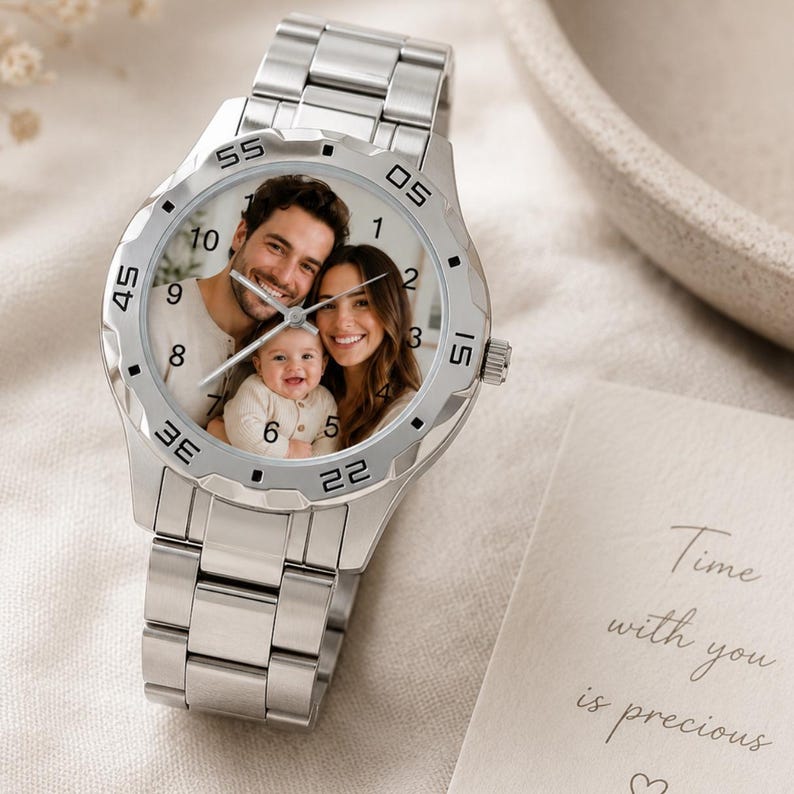 May include: A silver wristwatch with a photo of a family on the watch face. The watch has a stainless steel band and a round face with black numerals. The watch is next to a card that says "Time with you is precious."