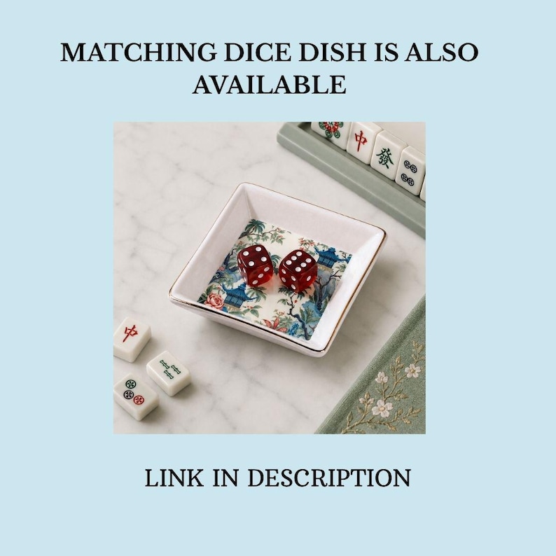 May include: A square white ceramic dish with a gold-toned rim, featuring a colorful floral and pagoda pattern on the interior base. Two translucent red dice with white pips rest inside the dish. Text reads: MATCHING DICE DISH IS ALSO AVAILABLE. LINK IN DESCRIPTION.
