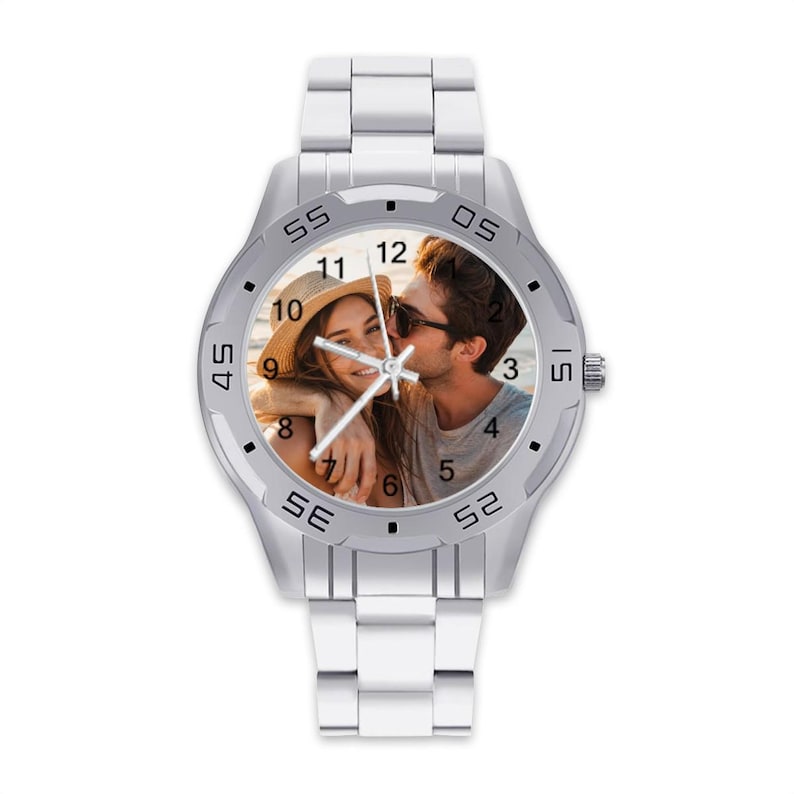 May include: A silver-toned wristwatch with a photo of a couple on the watch face. The watch has a silver band and a bezel with numbers and markers. The watch face displays the numbers 1 through 12.