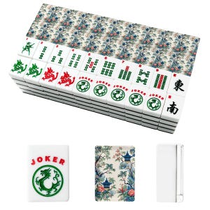 Op de afbeelding: Een set witte mahjongtegels met een decoratief bloemen- en pagodepatroon op de achterkant. De voorkant van de tegels toont groene en rode inktontwerpen, waaronder draken, het woord JOKER, genummerde bamboepakken en zwarte Chinese karakters.