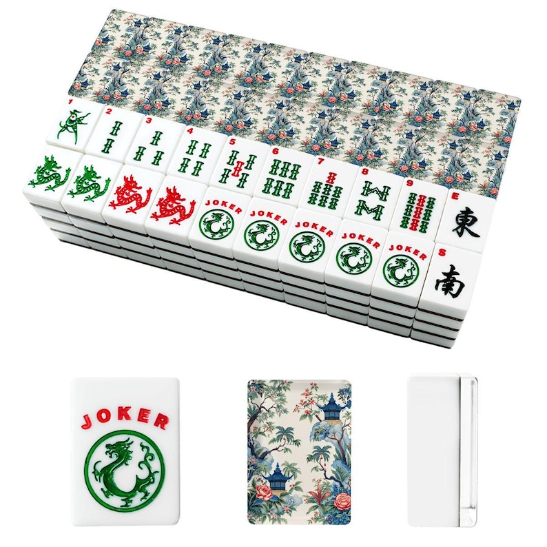 Op de afbeelding: Een set witte mahjongtegels met een decoratief bloemen- en pagodepatroon op de achterkant. De voorkant van de tegels toont groene en rode inktontwerpen, waaronder draken, het woord JOKER, genummerde bamboepakken en zwarte Chinese karakters.