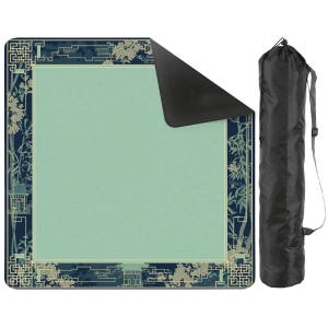 May include: A rectangular yoga mat with a light green center and a dark blue border featuring floral and architectural designs. A black carrying bag with a shoulder strap is next to the mat. The mat is designed for yoga and fitness.