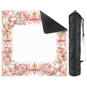 May include: A square picnic blanket featuring a white center and a border decorated with pink roses, teapots, teacups, macarons, gold fleur-de-lis, and pink bows. The blanket has a black underside and comes with a black cylindrical carrying bag.