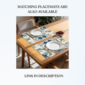 May include: Two rectangular placemats featuring a blue and green botanical and pagoda print on a cream background. Each placemat is set with a white plate, a silver fork, and a silver knife. The text MATCHING PLACEMATS ARE ALSO AVAILABLE is visible.