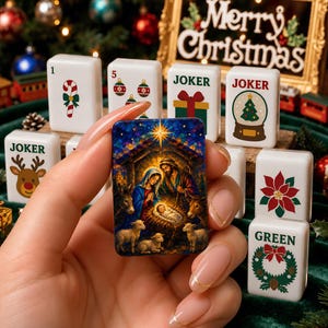 May include: A rectangular mahjong tile featuring a colorful nativity scene with a star, Mary, Joseph, the infant Jesus, and animals. Surrounding tiles display Christmas-themed graphics including candy canes, ornaments, gifts, snow globes, and reindeer.